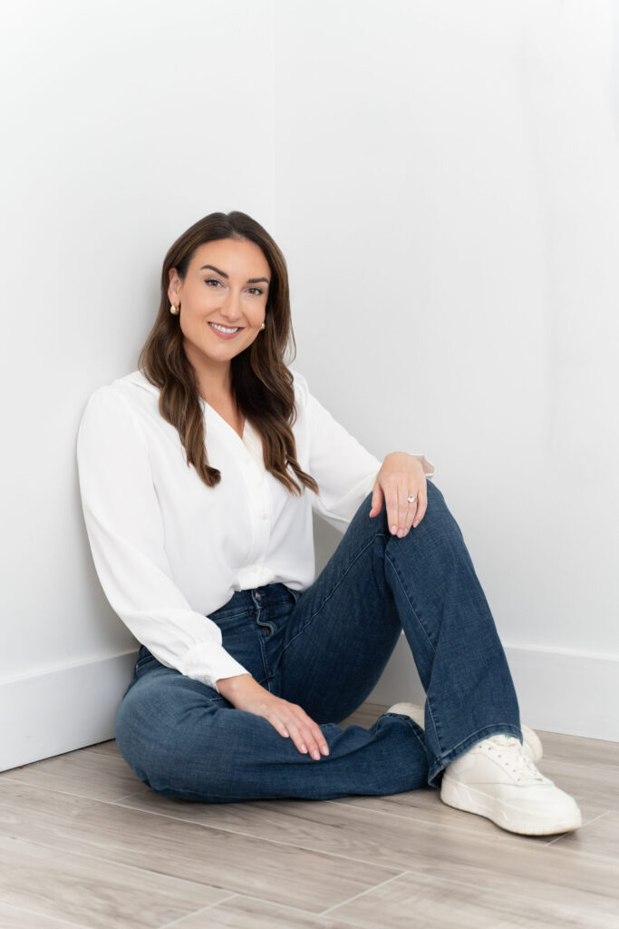 Woman casually sitting on the floor looking at the camera